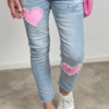 Stretchiga jeans i ljus tvätt med en rosa hjärtapplikation på bakfickan, dekorerad med glänsande pärlor. Finns i storlekar S-XL.