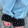 Svarta slipperssandaler med dekorativa svarta pärlor och zigzagbroderier – en elegant sko som passar både till fest och vardag.