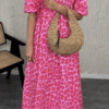 Klänning med rosa och cerise leopardprint i krinklad bomull, fotad utomhus i sommarljus. One size, luftig och feminin modell.